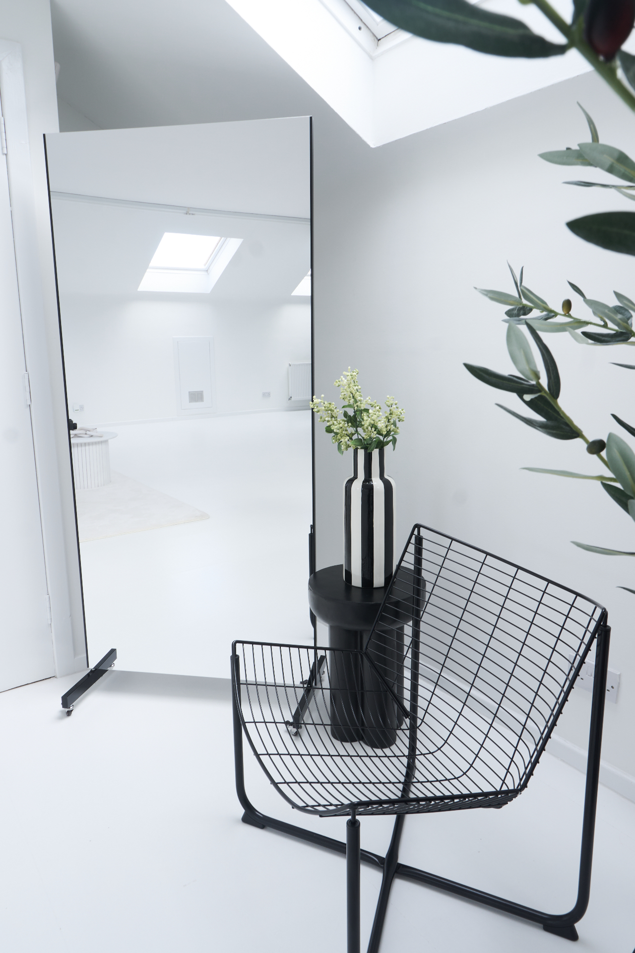 Minimal styling corner inside our content studio Glasgow with full-length mirror and wire chair