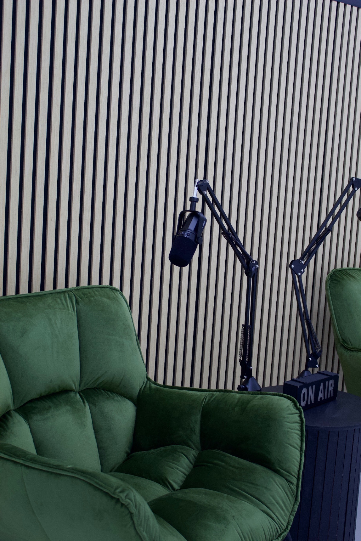 Green velvet podcast chairs and On Air sign in the Glasgow podcast studio